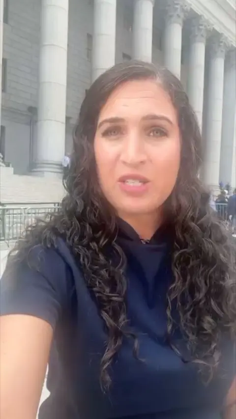 Nada wearing blue outside the courtroom.