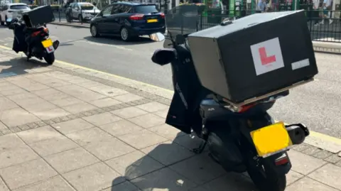 Two motorcycles parked up on the pavement