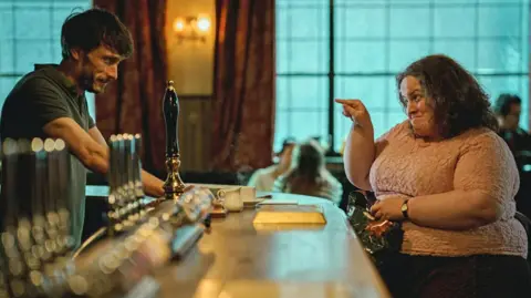 Netflix Baby Reindeer stars Richard Gadd and Jessica Gunning, sat across a bar 