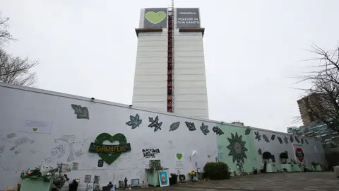 Jonathan Brady/PA Media Mural outside Grenfell Tower, with the tower in the background