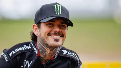 Man with tattoos on neck wearing a black hat