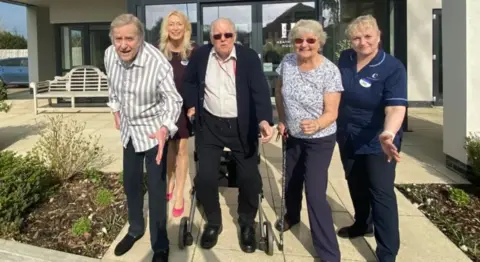 Care home residents and staff smiling for the camera