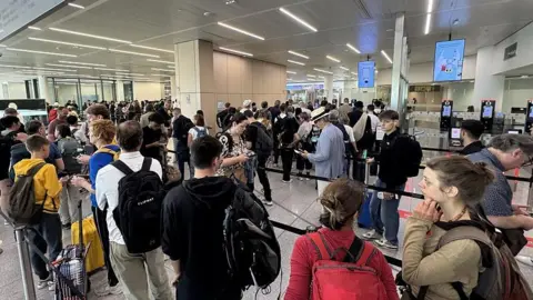Passengers wait in long queues at passport control in the departures terminal of Brussels Airport in Brussels, Belgium, on June 29, 2026.