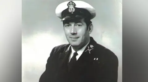 Family photo Black and white photo of Ernest Williams from when he was serving in the Royal Navy. He has on a Navy Uniform and hat.