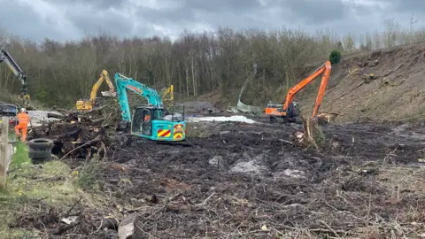 Workmen repairing damaged embankment