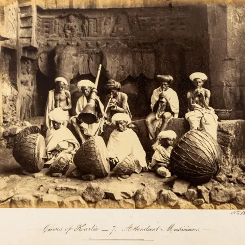 DAG Eight Indian musicians pose outside a cave in India's Maharashtra, holding their traditional drums and pipes in this undated photograph. 
