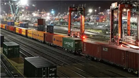 BBC Rail lines with a vast number of shipping containers at a port