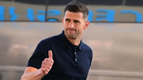 John Mousinho gives the thumbs-up to fans ahead of Portsmouth's game at Coventry