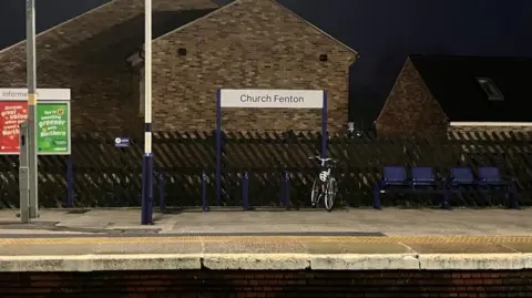 A railway station platform with a sign reading "Church Fenton".