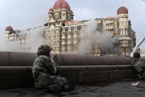 AFP Seorang prajurit India mengarahkan senjatanya ke arah Hotel Taj Mahal di Mumbai pada 29 November 2008, selama operasi militer.