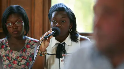 Haringey Council Linda Gyamfi holding a microphone and speaking at an event