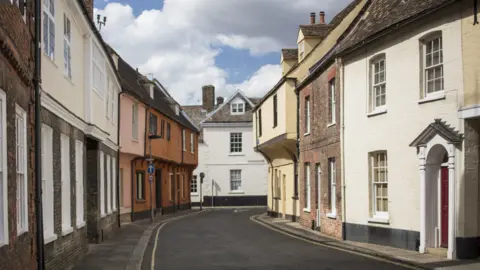 Getty Images Nelson Street in King's Lynn showing a narrow single yellow lined road with old 15th Century merchant housing on either side 
