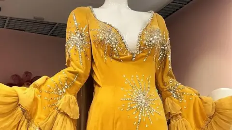 Lee Humphries Danny La Rue's yellow, sequinned dress on display at the exhibition in Cardiff