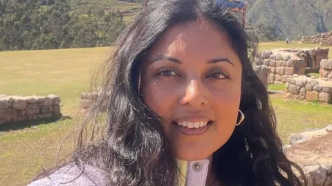 Saima Siddiqui Saima Siddiqui taking a selfie in front of some ruins.