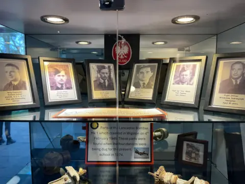 Photographs of the six airmen are inside a display cabinet alongside a sign explaining what happened 