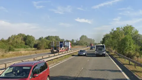 Google A dual carriageway with a black range rover towing a white caravan and a brown car coming up to overtake. 