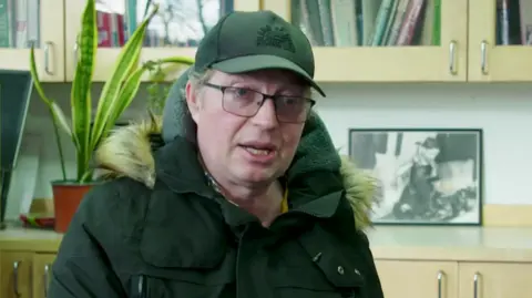 Sam van Rood in a black parka-style coat. 