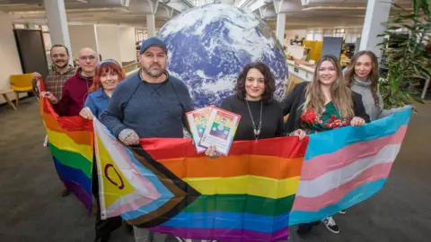 Stephen Lewis  Volunteers of Chippenham Pride hold a pride banner 