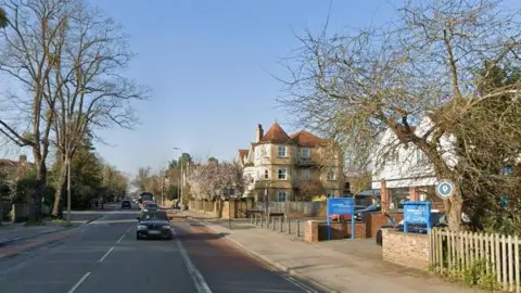 Google Street View of a main road in Oxford, large houses on one side, bus lanes on both sides.