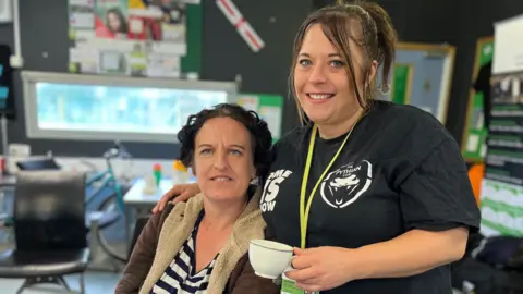 Woman with short black hair next to a woman with brown hair.