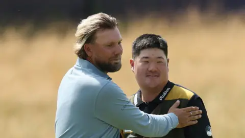 Dan Brown and Im Sung-jae embrace at the end of their round
