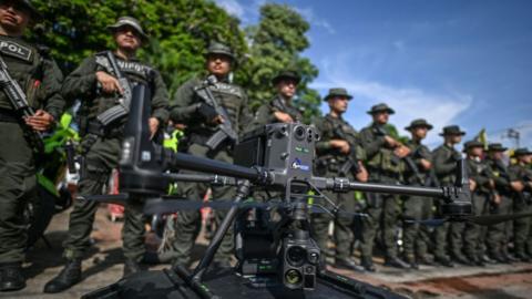 Police officers stand in formation behind a drone that will be used to increase the security in Jamundi, Valle del Cauca province, Colombia