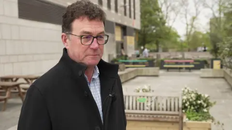 Stephen Manion, executive director of GO! Southampton standing next to a damaged bench by Mettrick coffee shop by the Guildhall in Southampton, Hampshire