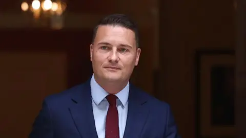 Wes Streeting wearing a neutral expression as he emerges from 10 Downing Street