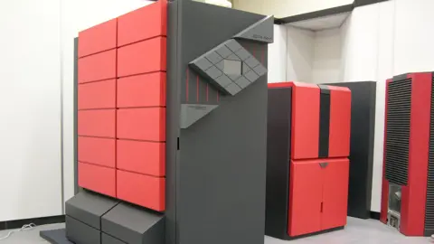 Dan Goldsmith Several huge units in a office-type space which look a bit like giant desktop computer towers. They are black and red, with the Cray logo on them.