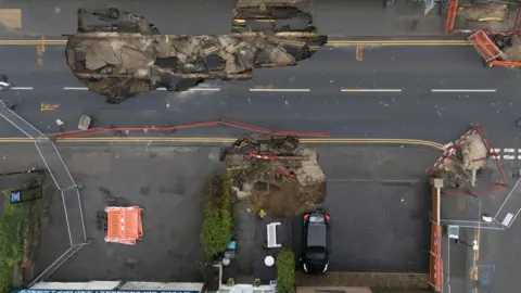 PA Media An aerial view of the sinkholes that have opened in the centre of Godstone.