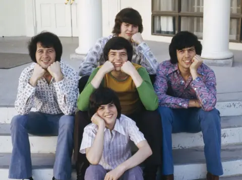 Getty Images The Osmonds, sekitar tahun 1972. Depan; Doni. Tengah, kiri ke kanan: Wayne, Jay dan Alan. Kembali; Merrill.