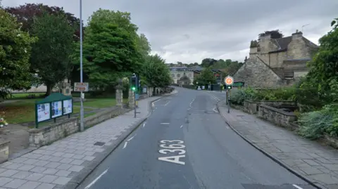 The pedestrian crossing in Bradford-on-Avon. There are slabbed pavements to both sides of the road.