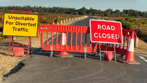Cones, barriers and signs saying road closed, unsuitable for diverting traffic