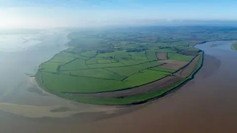 Aerial view of a farmland peninsula, with the brown-coloured River Severn curving around its edge.