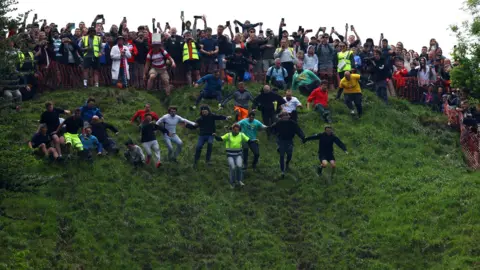 Reuters Crowds at the top of the hill as men run down