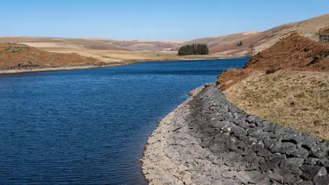 Elan Valley Craig Goch Reservoir pictured in March with water and surrounding mountains visible and rocks along the shore