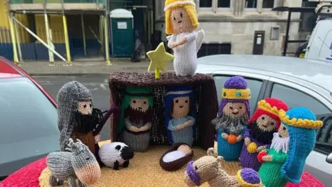 Slimming World Hereford with Jo A nativity scene shows Mary and Joseph in a stable with the baby Jesus in a crib in front of them. A shepherd stands to the left with a sheep and the three wise men can be seen on the left with a camel. There is an angel on top of the stable with a star.