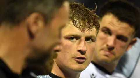 Jac Morgan listens to Ospreys head coach Mark Jones in a team huddle