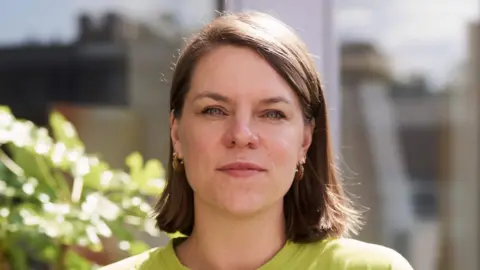 Fawcett Society A head and shoulders image of a woman with shoulder length brown hair wearing a green shirt