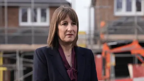 BBC Rachel Reeves being interviewed near two houses under construction