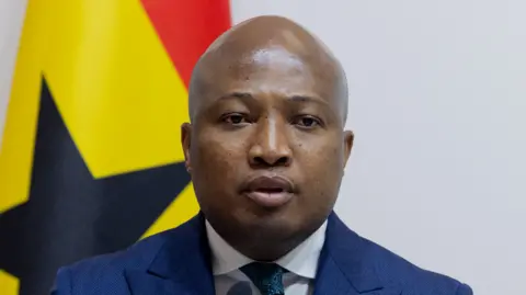 AFP via Getty Images Ghana's foreign minister Samuel Okudzeto Ablakwa is pictured in front of the Ghanaian flag.