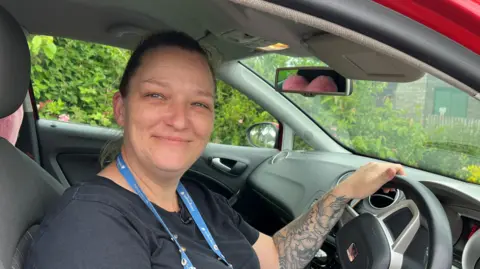 Homecare worker Amanda Nottingham sits at the wheel of her car