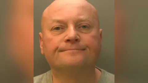 Sussex Police A mugshot bald man