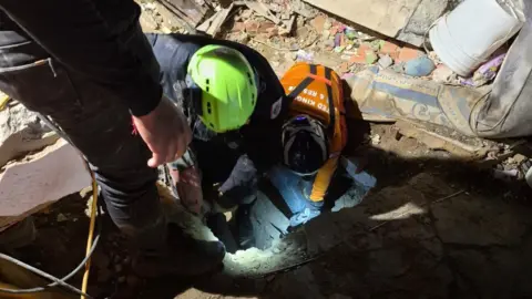Lancashire Fire and Rescue Service People in hard hats digging through rubble