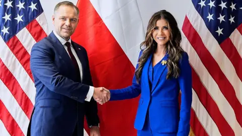 Getty Images US Homeland Security Secretary Kristi Noem shakes hands with Nawrocki