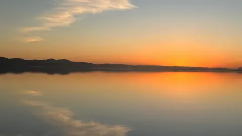 Sunset of orange glow reflected in the River Tay.