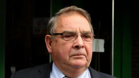 PA Media Lord Hanningfield pictured in 2011. He is wearing glasses, a dark suit and striped shirt. 