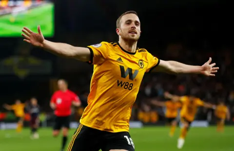 Diogo Jota in his Wolverhampton football kit running with his arms open during a game