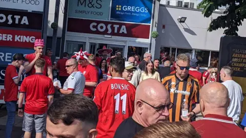 Alana Ennis Fans, some wearing Hull City shirts, some wearing Middlesborough shirts, mix at motorway services 