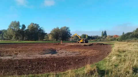 Essex and Suffolk Rivers Trust A large amount of land and a large yellow digger in the corner.
